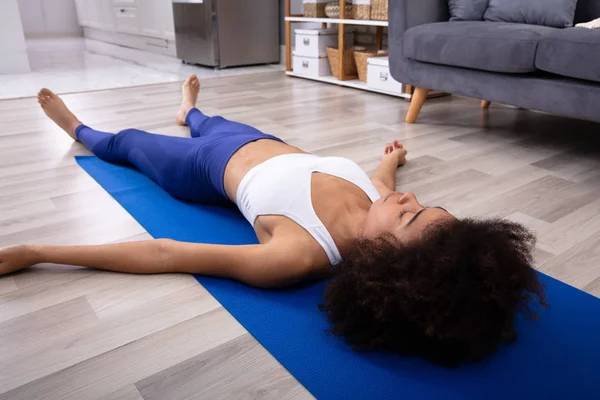 Atletische Jonge Vrouw Liggend Het Blauwe Yoga Mat Hardhouten Vloer — Stockfoto