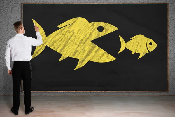 Bakifrån Affärsman Ritning Skiss Stor Fisk Äter Småfisk Blackboard — Stockfoto
