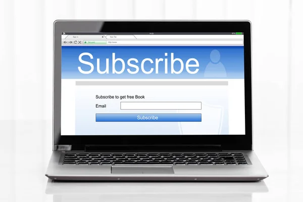 ホワイトサーフェス上の画面にオンラインサブスクリプションフォームを表示するノートパソコンのクローズアップ — ストック写真