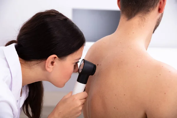 Médecin Féminin Examinant Peau Pigmentée Sur Dos Homme Avec Dermatoscope — Photo