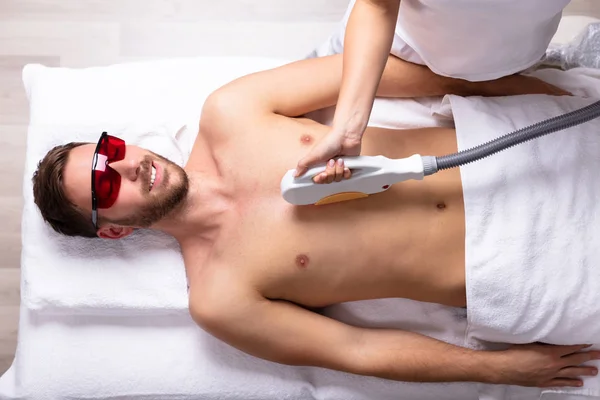 Ung Kvinnlig Kosmetolog Som Ger Laserbehandling Avslappnad Mans Bröst — Stockfoto