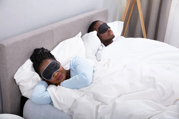 Νεαρό Αφρικανικό Ζευγάρι Κοιμάται Στο Κρεβάτι Χρησιμοποιώντας Μάσκα Ματιών Στην — Φωτογραφία Αρχείου