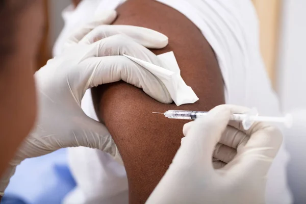 クリニックで男性患者の腕に注射器を注入する医師のクローズ アップ — ストック写真