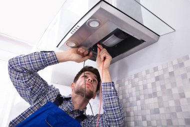 Tamirci mutfak Extractor süzgecinde mutfak multimetre ile kontrol