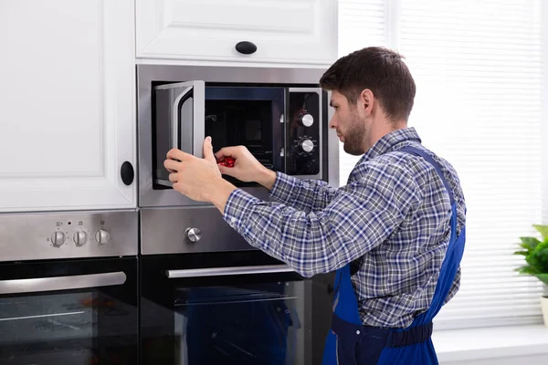 Seitenansicht Eines Jungen Mannes Der Mikrowellenherd Küche Repariert — Stockfoto