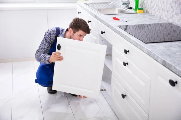 Agachamento Reparador Fixando Porta Dissipador Cozinha — Fotografia de Stock