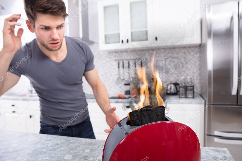 Portrait Of Scary Man Looking At Slice Of Burn Coming Out Of Toaster