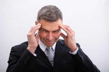 Beyaz arka plan baş ağrısı muzdarip olgun işadamı portresi
