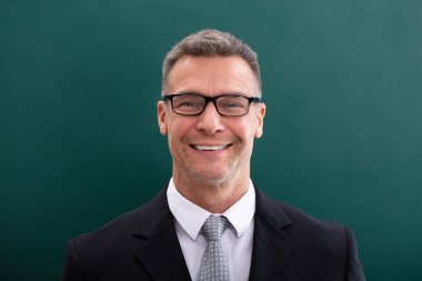 Gözlük yeşil arka plana karşı mutlu işadamı