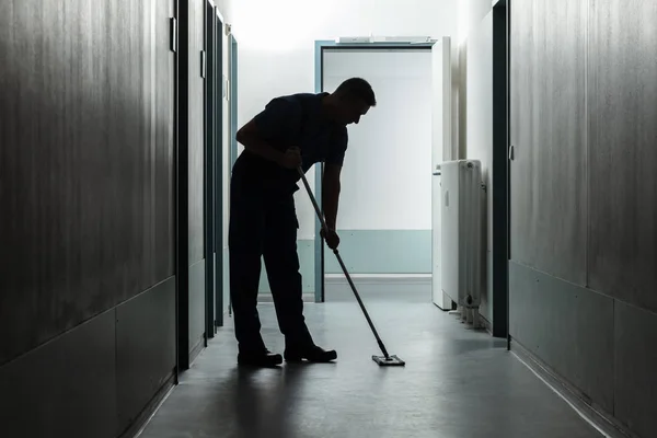 Silhouet Van Een Mannelijke Conciërge Schoonmaakhal — Stockfoto