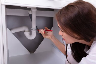 Ayarlanabilir anahtarı ile lavabo tamiri genç bir kadının yakın çekim