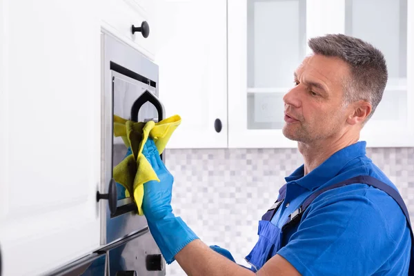 Side View Male Janitor Cleaning Oven Yellow Napkin Kitchen — Stock Photo, Image