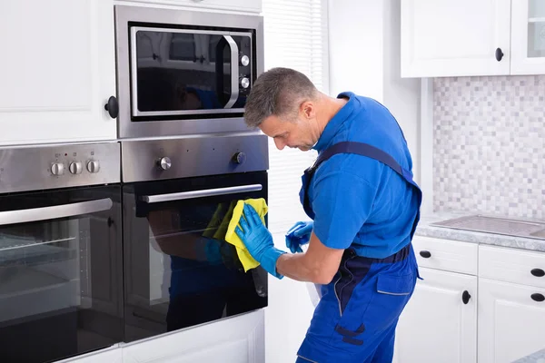Close Smiling Male Janitor Cleaning Oven Yellow Napkin Kitchen — Stock Photo, Image