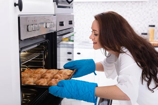 Side View Happy Young Woman Removing Tray Baked Croissants Oven — Stock Photo, Image