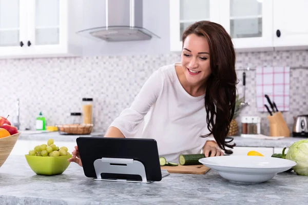 Ευτυχισμένη Γυναίκα Χρησιμοποιώντας Ψηφιακό Tablet Κατά Μαγείρεμα Των Τροφίμων Στην — Φωτογραφία Αρχείου