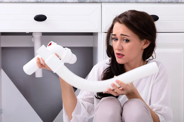 Mulher Perturbada Olhando Para Tubo Dissipador Danificado — Fotografia de Stock