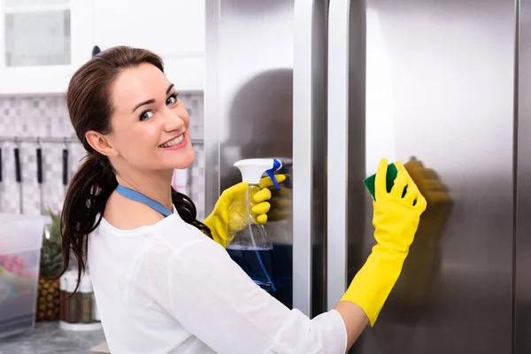 Feliz Joven Mujer Que Limpia Refrigerador Con Esponja Aerosol Botella —  Fotos de Stock