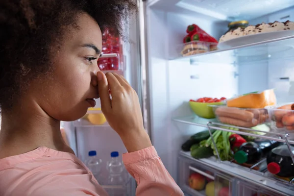 Вид Збоку Молодої Жінки Визнаючи Поганий Запах Холодильника Покриває Ніс — стокове фото