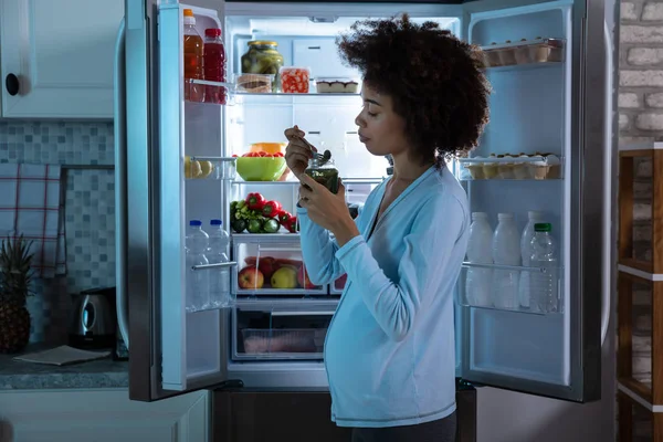 Embarazada Mujer Comiendo Encurtido Tarro Pie Delante Refrigerador Abierto — Foto de Stock