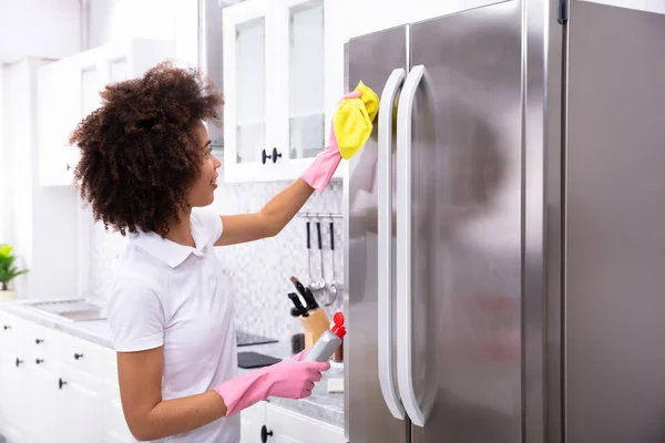 Close Serious Young Woman Cleaning Refrigerator Yellow Napkin Spray Detergent — Stock Photo, Image