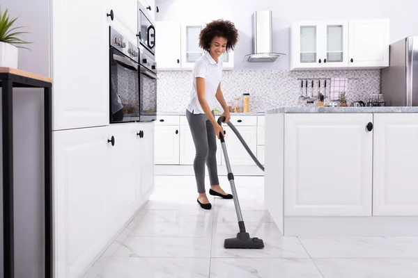 Close Uma Jovem Mulher Limpando Chão Cozinha Branca Com Aspirador — Fotografia de Stock