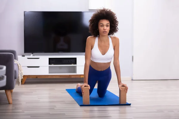 Passar Ung Kvinna Med Träklossar Medan Gör Övningen Yogamatta Vardagsrummet — Stockfoto