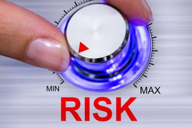 Bir kişinin el risk regülatör düğmesi gri arka plan üzerinde en aza indirme