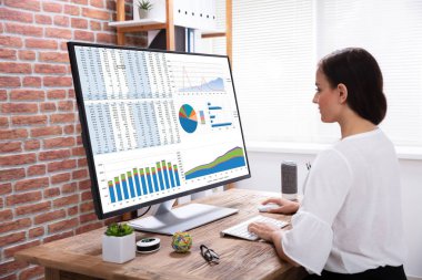 Bir iş kadını ofiste ahşap masanın üzerinde grafik bilgisayar üzerinde analiz Close-up