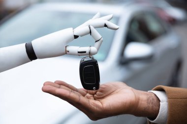 Close-up Of A Robot's Hand Giving Car Key To Man clipart