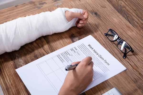 Close Businesswoman White Bandage Hand Filling Work Injury Claim Form — Stock Photo, Image