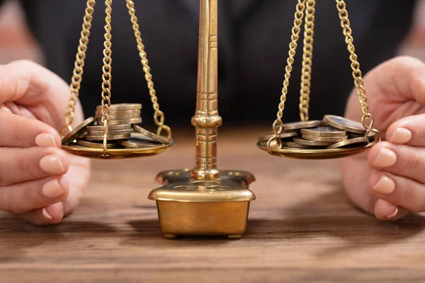 Tahta masanın üzerindeki madeni paraların korunması için bir insanın eline yakın çekim.