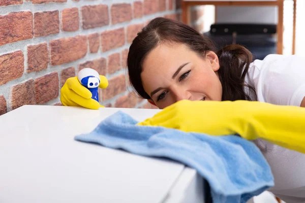 Gülümseyen Genç Kadın Mobilyaların Sprey Şişeyle Evde Temizlik — Stok fotoğraf