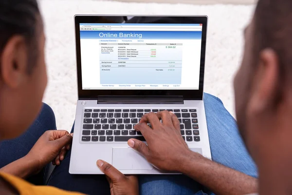 ラップトップでオンラインバンキングを行うアフリカのカップルのクローズアップ — ストック写真