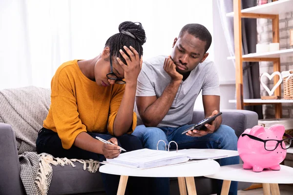 Trauriges Afrikanisches Paar Sitzt Auf Sofa Und Prüft Rechnung — Stockfoto