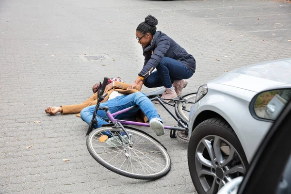 Jovem Mulher Olhando Inconsciente Masculino Ciclista Deitado Rua Após Acidente — Fotografia de Stock