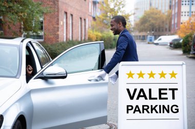 Mutlu Erkek Uşak Otomobil Kapısını Otopark Tabelasının yanında Açıyor