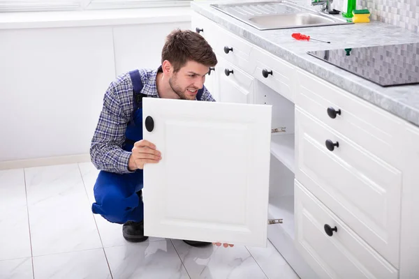 Smiling Handyman Montagem Uma Nova Porta Sob Cozinha — Fotografia de Stock