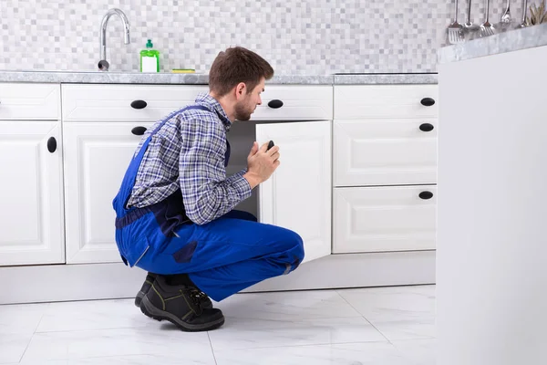 Agachamento Reparador Fixando Porta Dissipador Cozinha — Fotografia de Stock