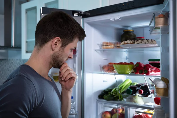 冷蔵庫で食べ物を探しているハンサムな男 — ストック写真