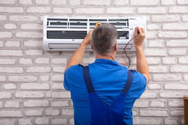 Erkek Elektrikçi Klimayı Dijital Çokölçer ile Kontrol Ediyor