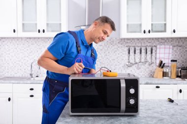Erkek Ustabaşı Mutfakta Mikrodalgayı Onarıyor Dijital Çokölçer Kullanıyor