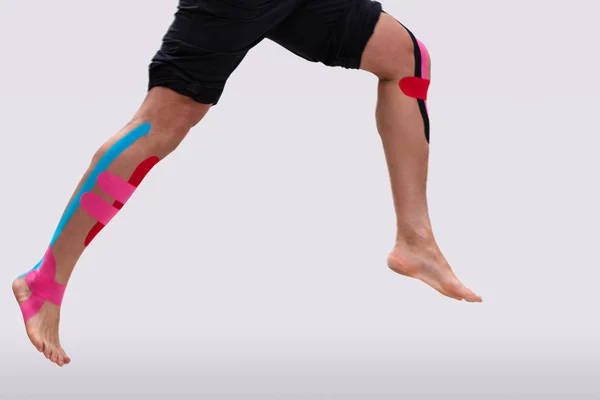 Low Section Man Running Physio Tape His Legs White Background — Stock Photo, Image