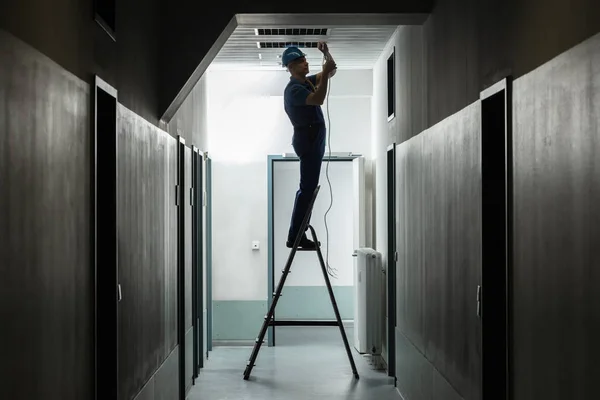 Silhouette Male Electrician Step Ladder Installing Light Corridor — Stock Photo, Image