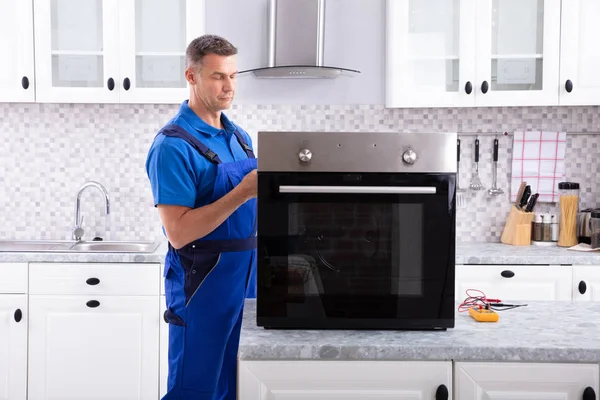 Reif Male Technician Reparatur Ofen Auf Küche Worktop — Stockfoto
