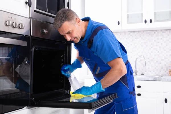 Close Homem Sorridente Faxineiro Forno Limpeza Com Guardanapo Amarelo Cozinha — Fotografia de Stock