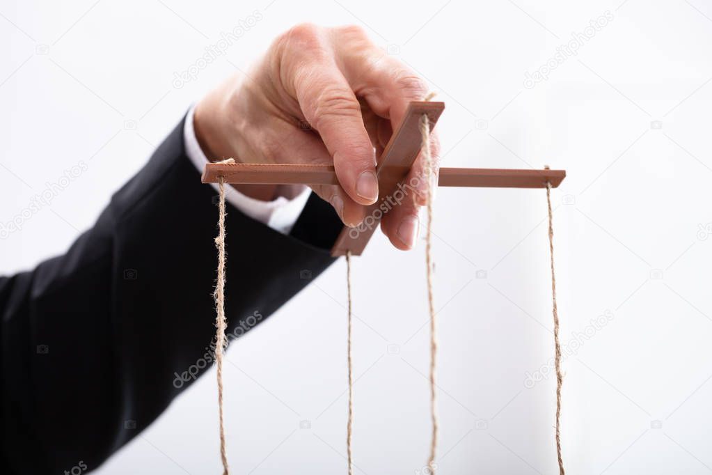 Close-up Of A Businessperson's Hand Manipulating Marionette With A String 