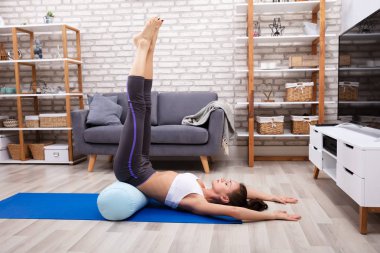 Genç kadının mavi Yoga Mat üzerinde egzersiz germe yapması