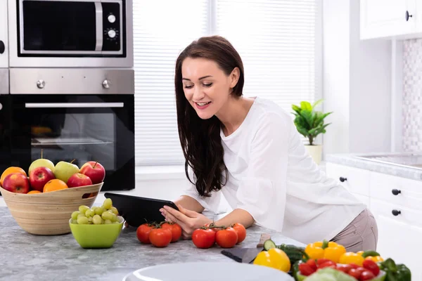 Mujer Joven Feliz Usando Tableta Digital Cerca Verduras Frescas Mostrador —  Fotos de Stock