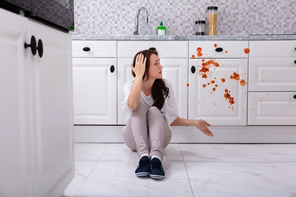 Mulher Triste Sentada Chão Com Alimentos Derramados Cozinha — Fotografia de Stock
