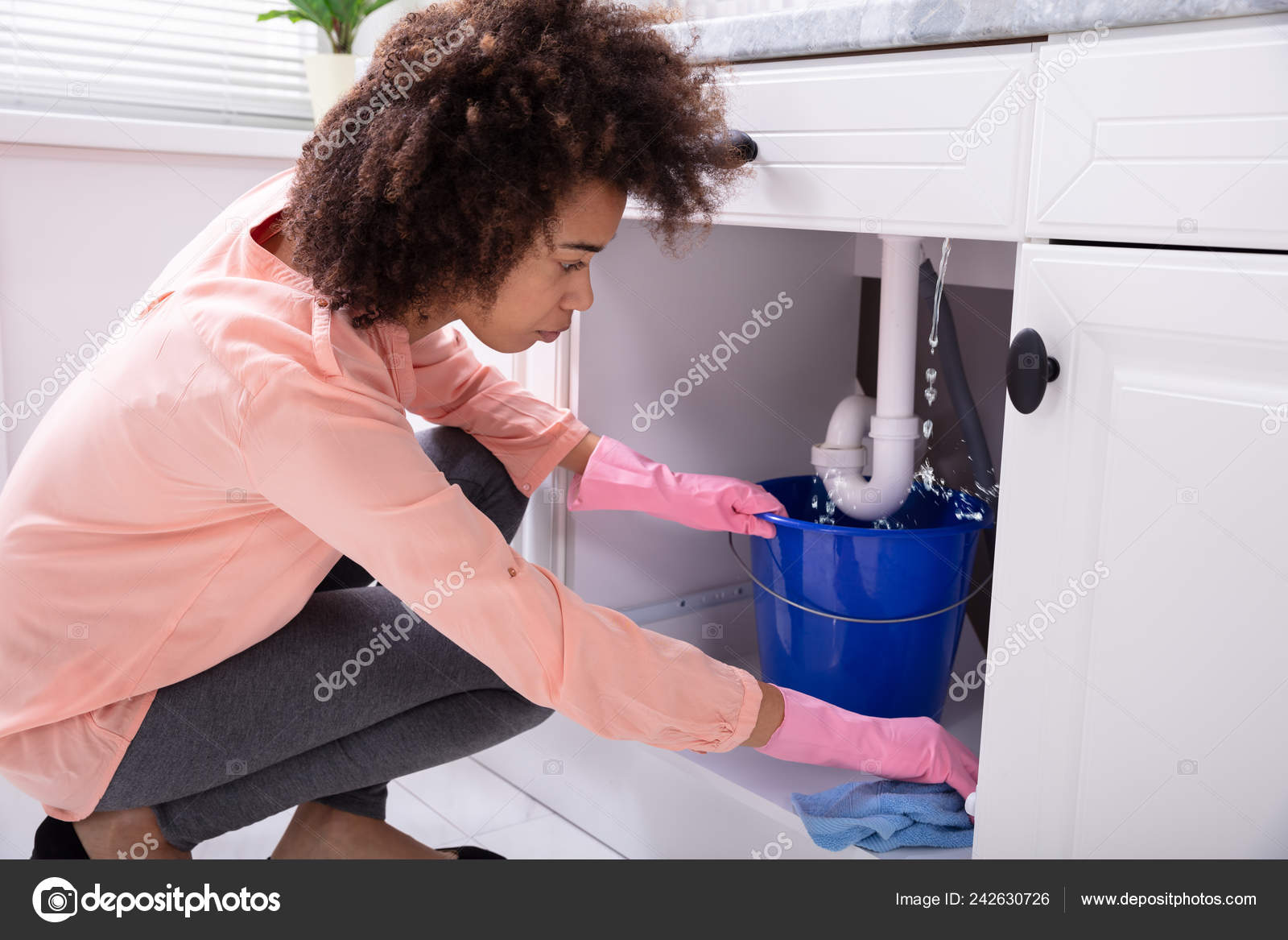 Close Young Woman Placing Blue Bucket Water Leaking Sink Pipe Stock